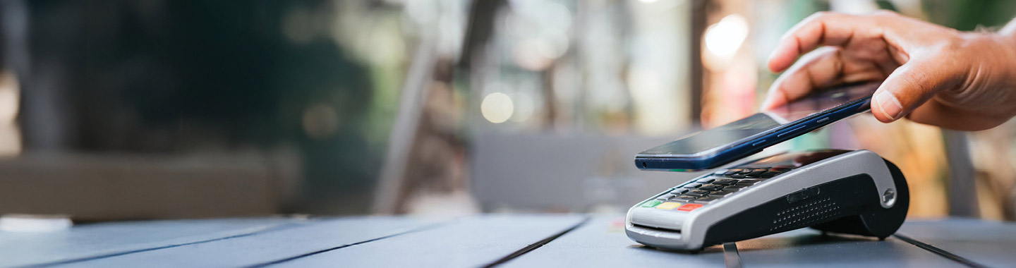 hand holding smartphone to pay credit card kiosk, TCU